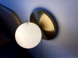 brushed brass round wall lamp with round frosted glass shade. Light turned on